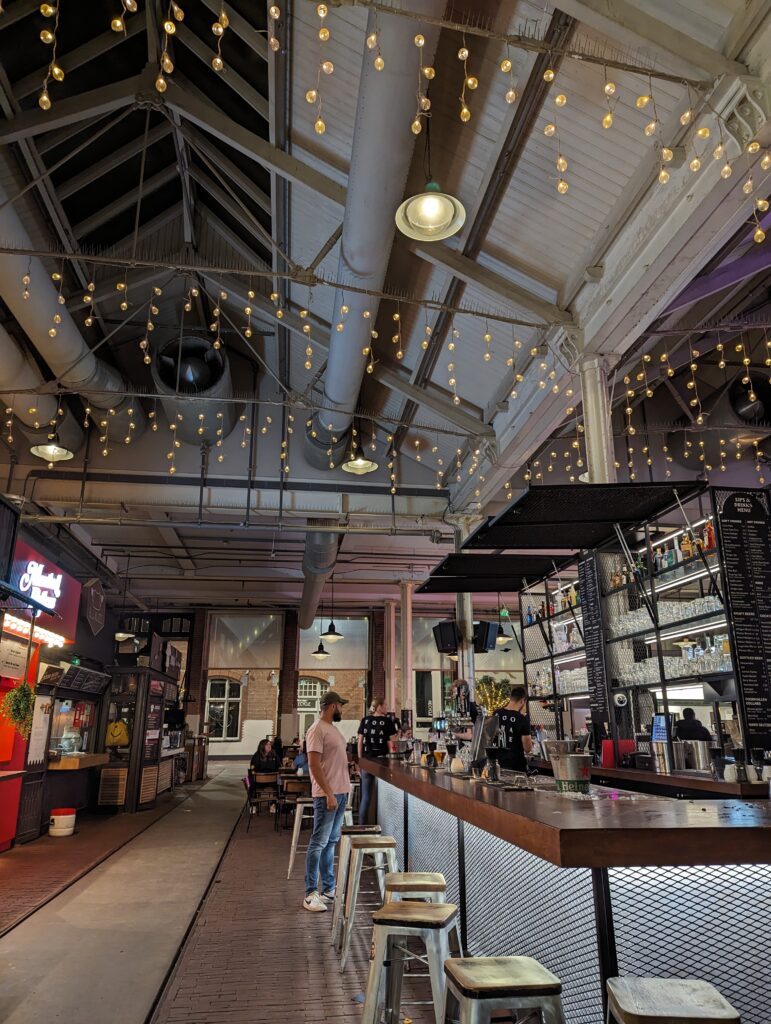 a big warehouse with fairy lights and a bar wedged into the middle of it.