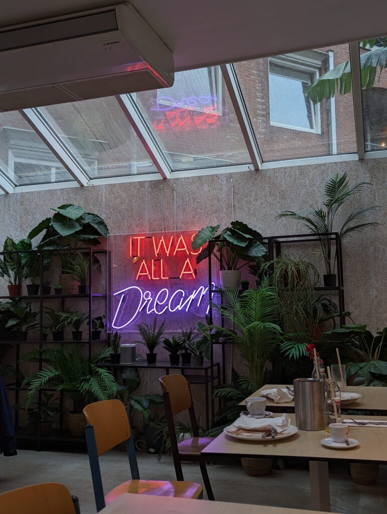 a skylight, fake plants and a neon sign in an annoyingly instagrammable pancake place.